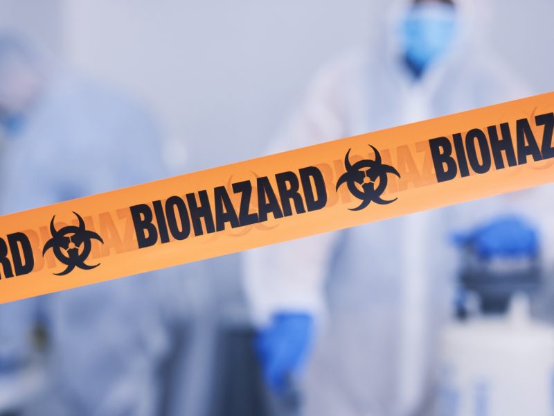 Biohazard, tape and people with caution working with toxic, biology or team disinfect dangerous bac
