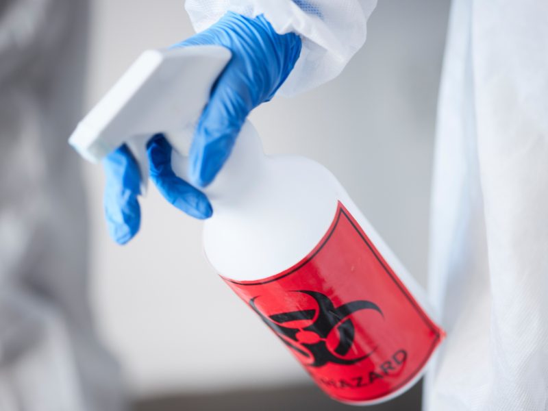 Hazmat suit, spray bottle and gloves for biohazard, covid and stop virus for safety, protection or